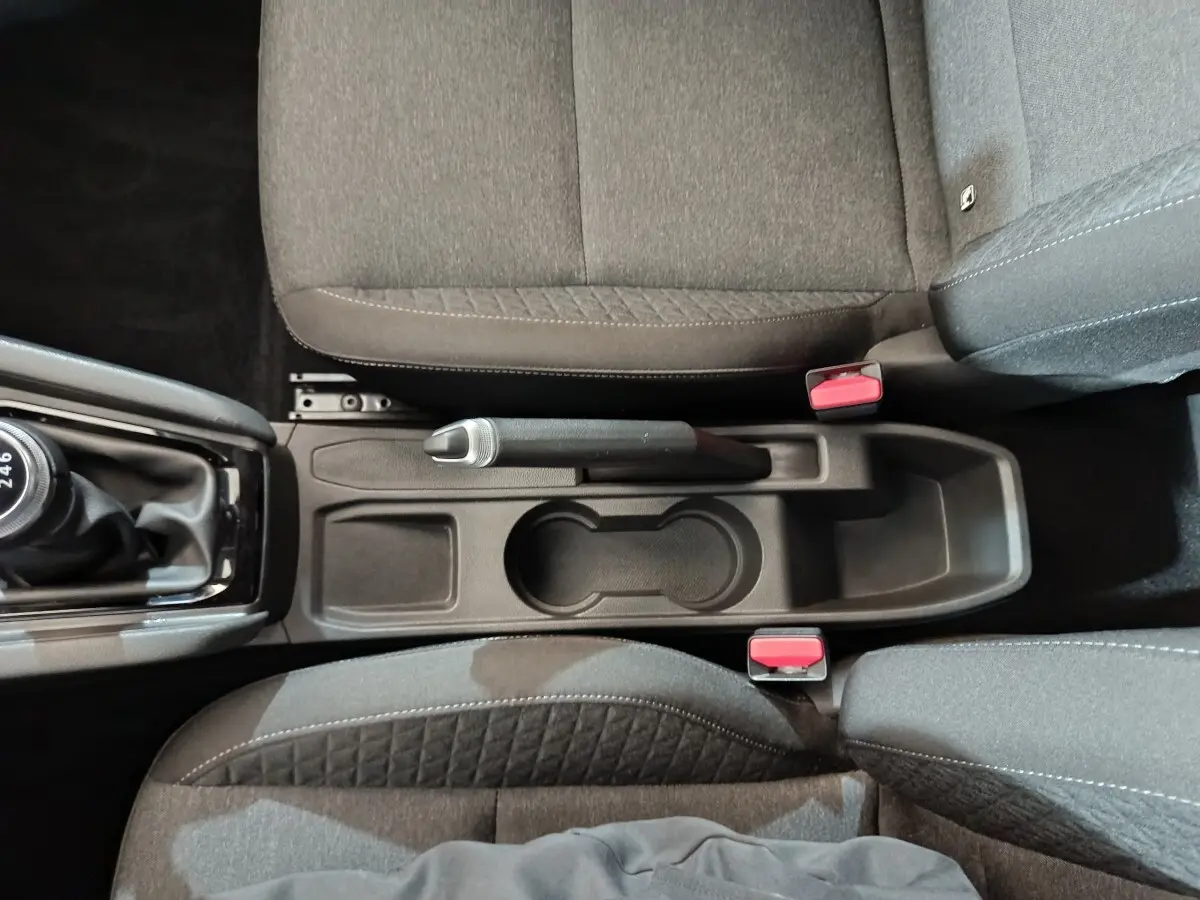 Vue intérieure plongeante sur la console centrale noire et les sièges tissu gris de la Renault Clio Equilibre TCe 90 2023.