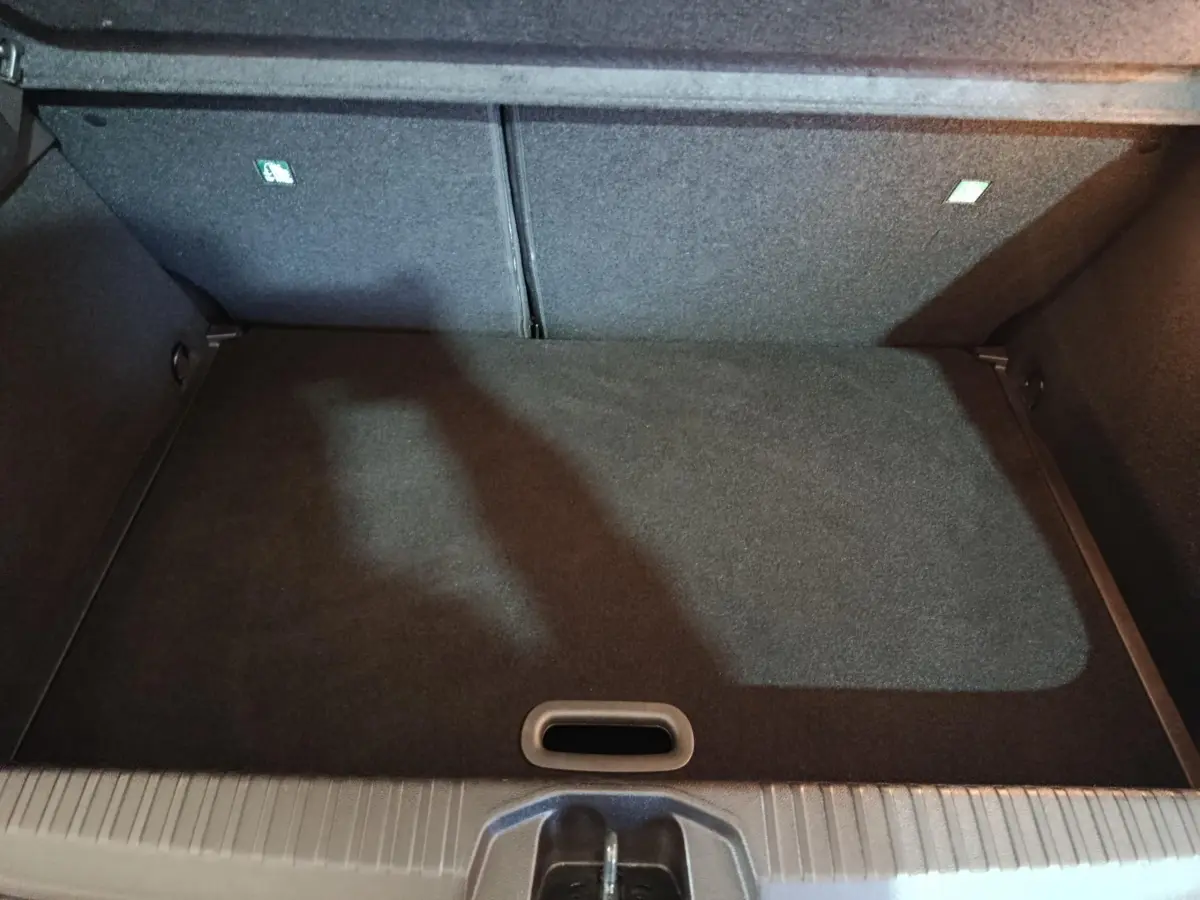 Coffre spacieux de Renault Clio Equilibre TCe 90 2023, vue intérieure avec plancher plat et revêtement gris foncé.