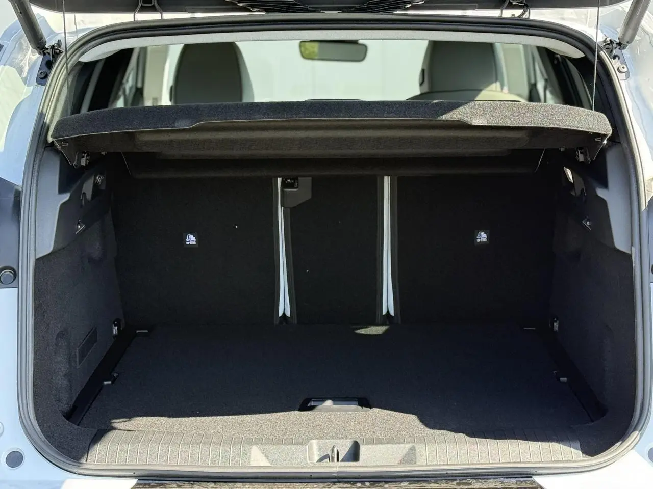 Coffre ouvert vu de l'arrière du Citroën C5 Aircross blanc Okénite, montrant un espace de chargement spacieux et noir.