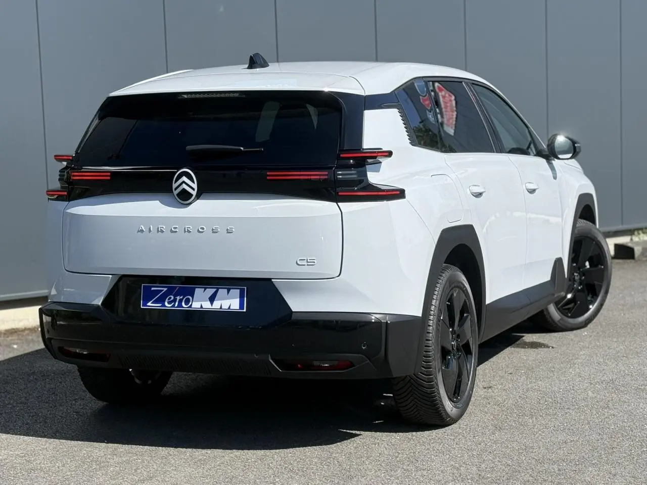 Vue 3/4 arrière droite du Citroën C5 Aircross blanc Okénite avec toit noir et jantes alliage noires.