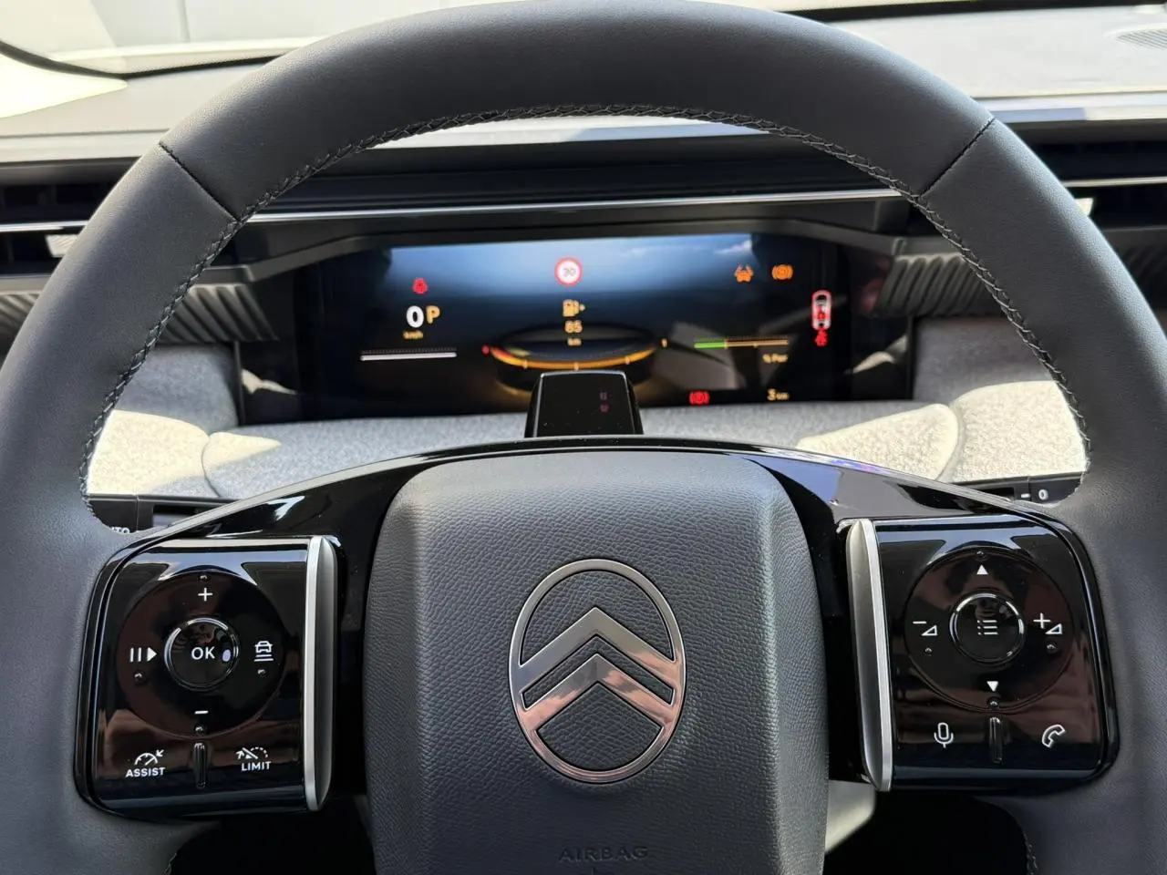 Vue rapprochée du volant noir brillant de la Citroën C5 Aircross 2025 avec commandes intégrées et tableau de bord numérique.