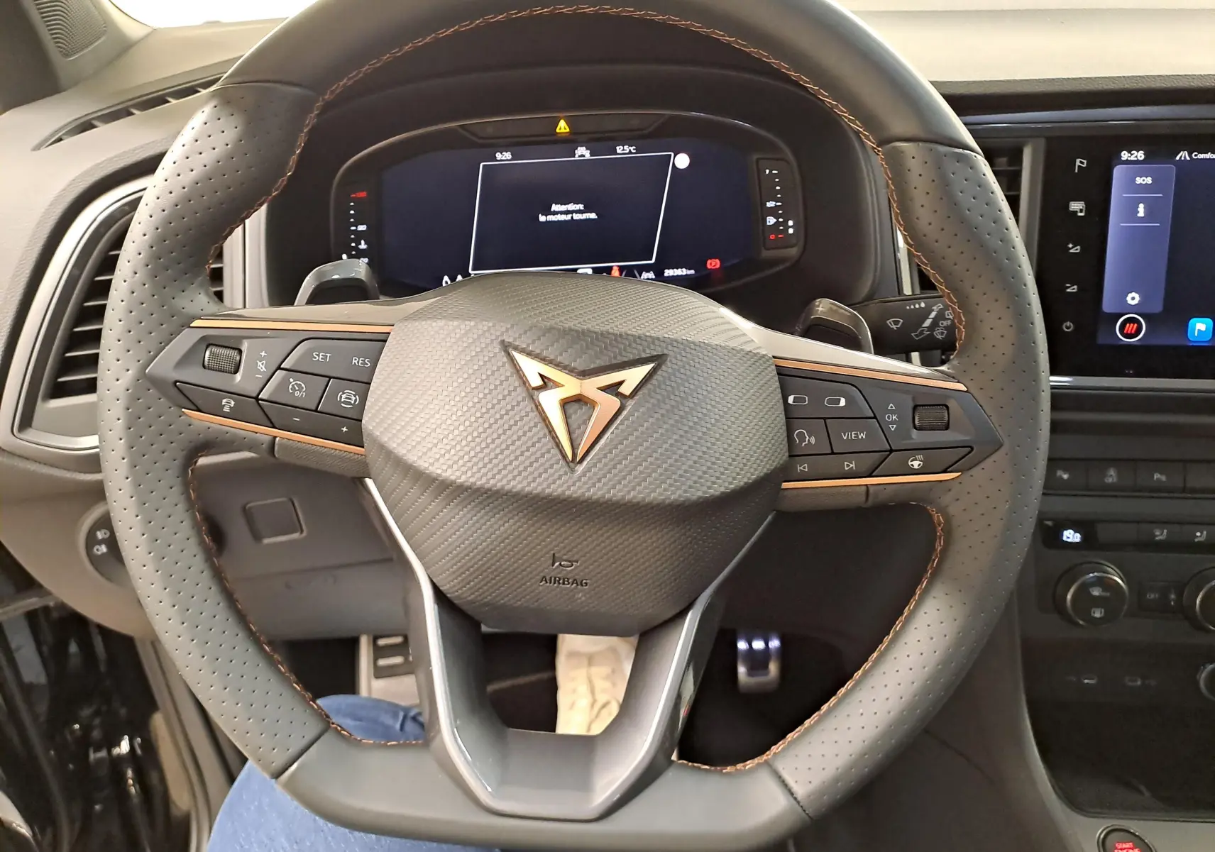 Vue rapprochée du volant perforé noir avec surpiqûres cuivrées et logo CUPRA au centre du SUV Ateca 2024.