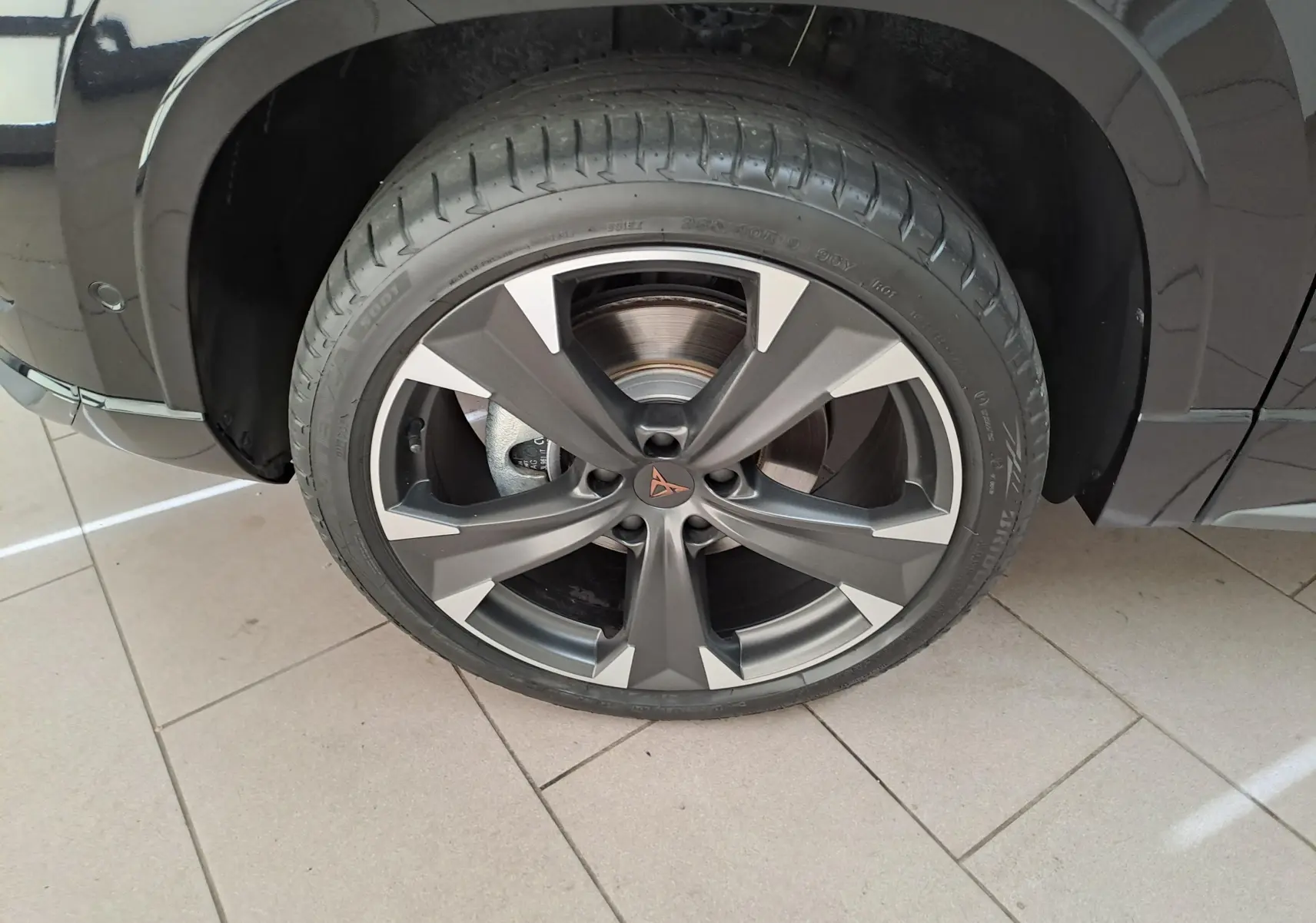 Gros plan sur la roue avant gauche du CUPRA Ateca 2024 noir magique, mettant en valeur la jante alliage distinctive.