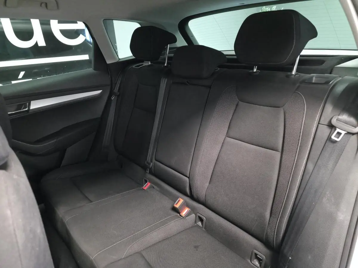 Vue intérieure du côté gauche de la banquette arrière noire du Skoda Karoq 2024 avec appuie-têtes et ceintures visibles.