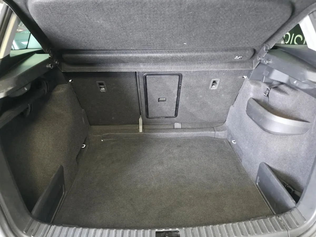 Coffre ouvert du Skoda Karoq blanc 2024, montrant un espace de rangement propre et bien agencé avec trappe centrale.