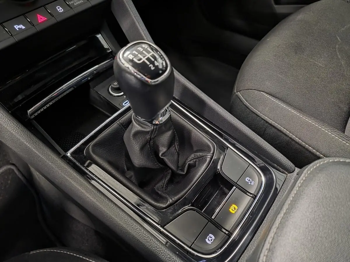 Gros plan sur le levier de vitesses manuel noir et la console centrale du Skoda Karoq 2024, intérieur tissu noir.