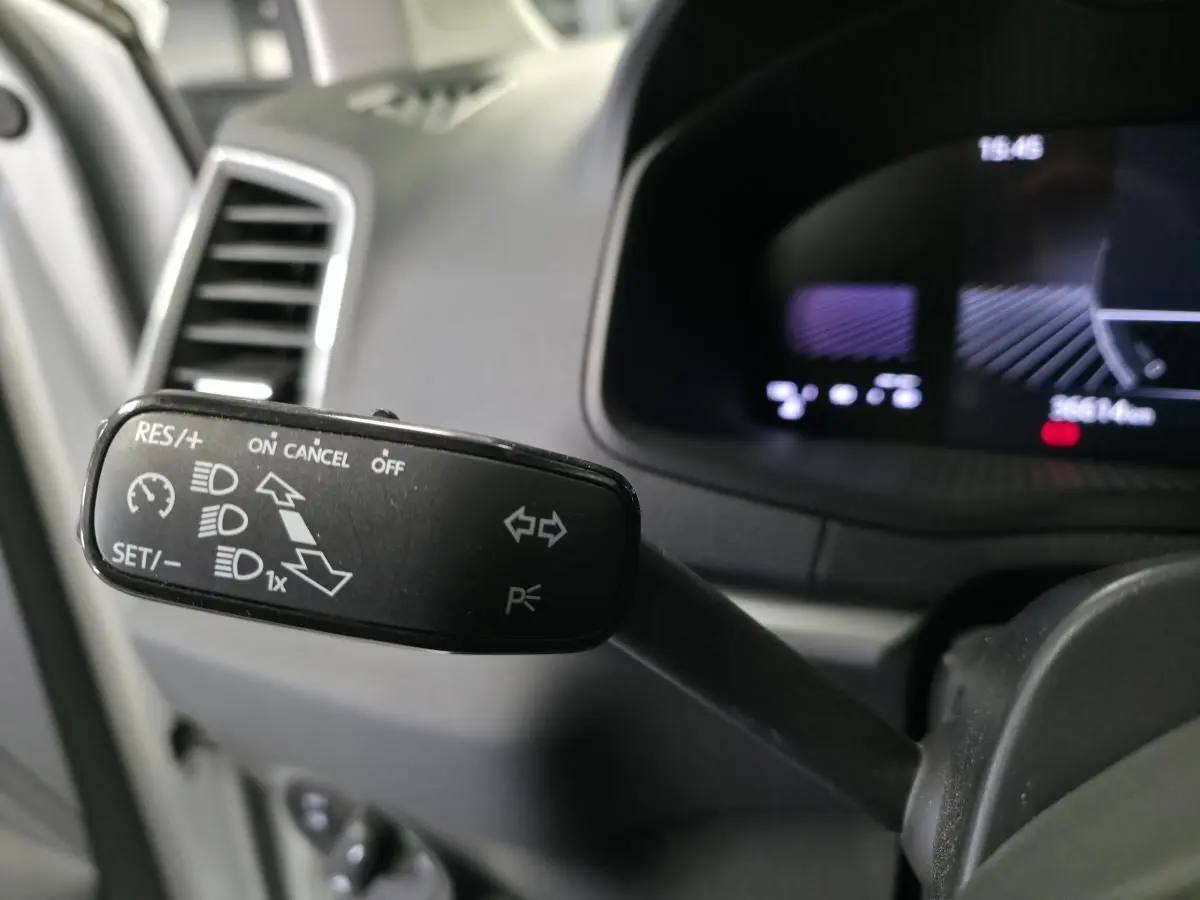 Gros plan sur la commande de régulateur de vitesse et clignotants côté gauche du tableau de bord noir du Skoda Karoq 2024.