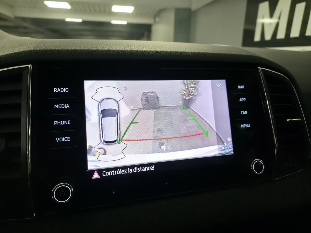 Écran tactile intérieur du Skoda Karoq 2024 montrant l’aide au stationnement avec caméra de recul active.
