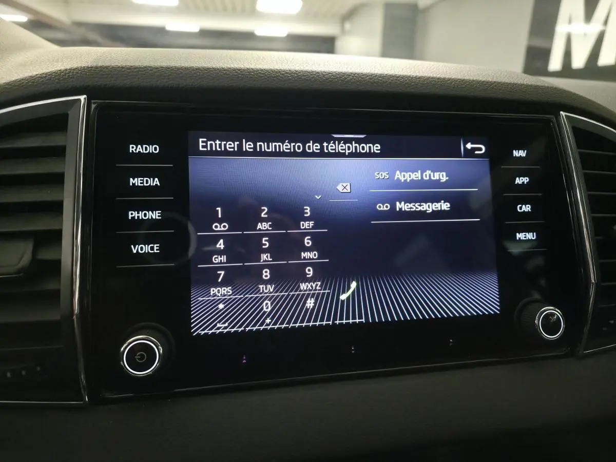 Écran tactile central du tableau de bord du Skoda Karoq 2024 affichant le clavier pour entrer un numéro de téléphone.