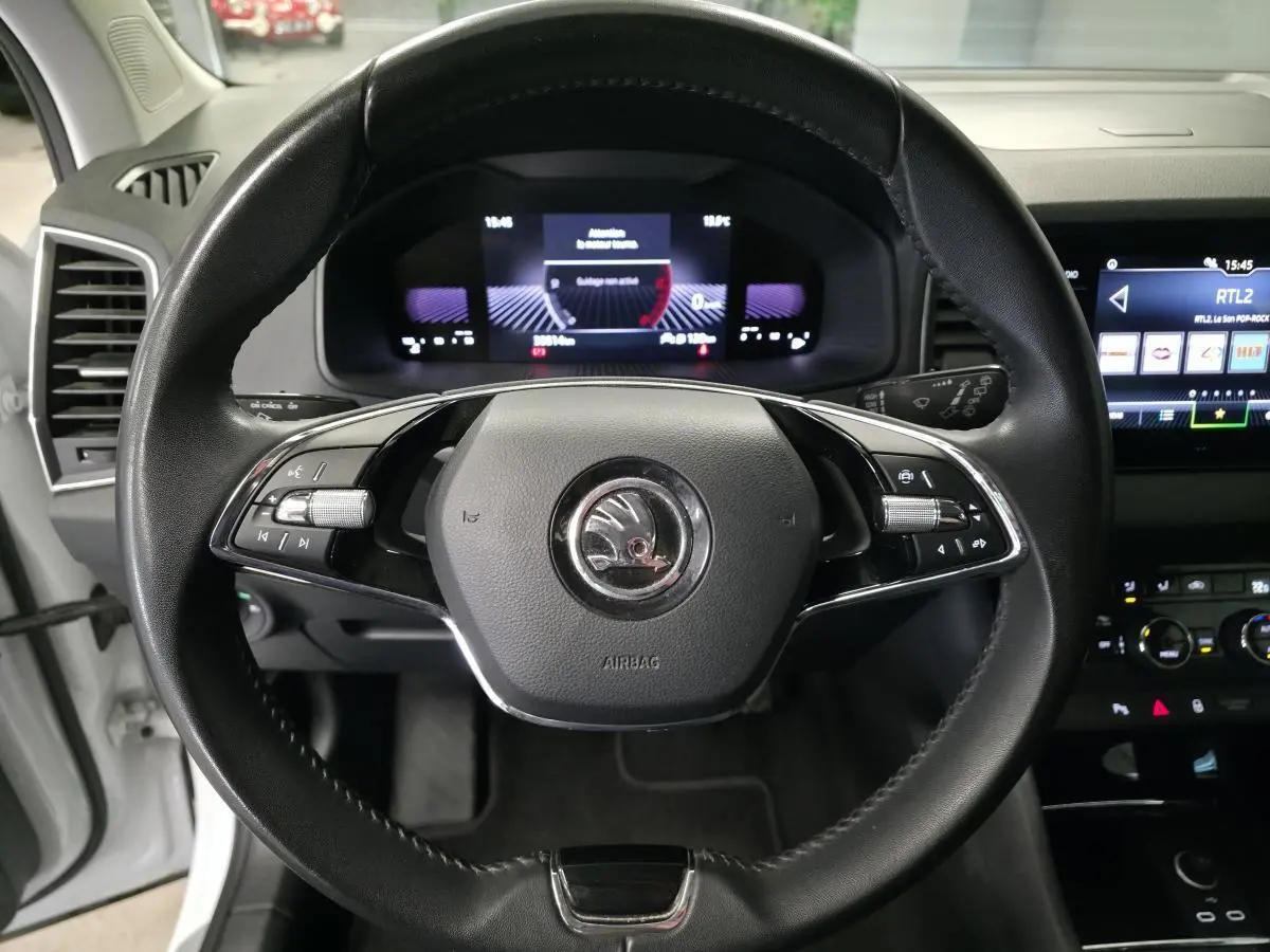 Vue frontale du volant noir de la Skoda Karoq 2024 avec tableau de bord digital et écran tactile visible à droite.