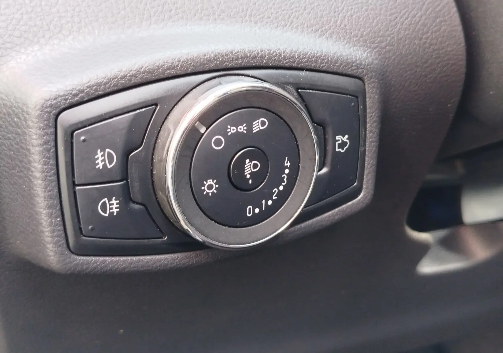 Gros plan sur la molette de réglage des phares noirs dans l'habitacle du Ford KA+ 2020, finition Édition Noire.