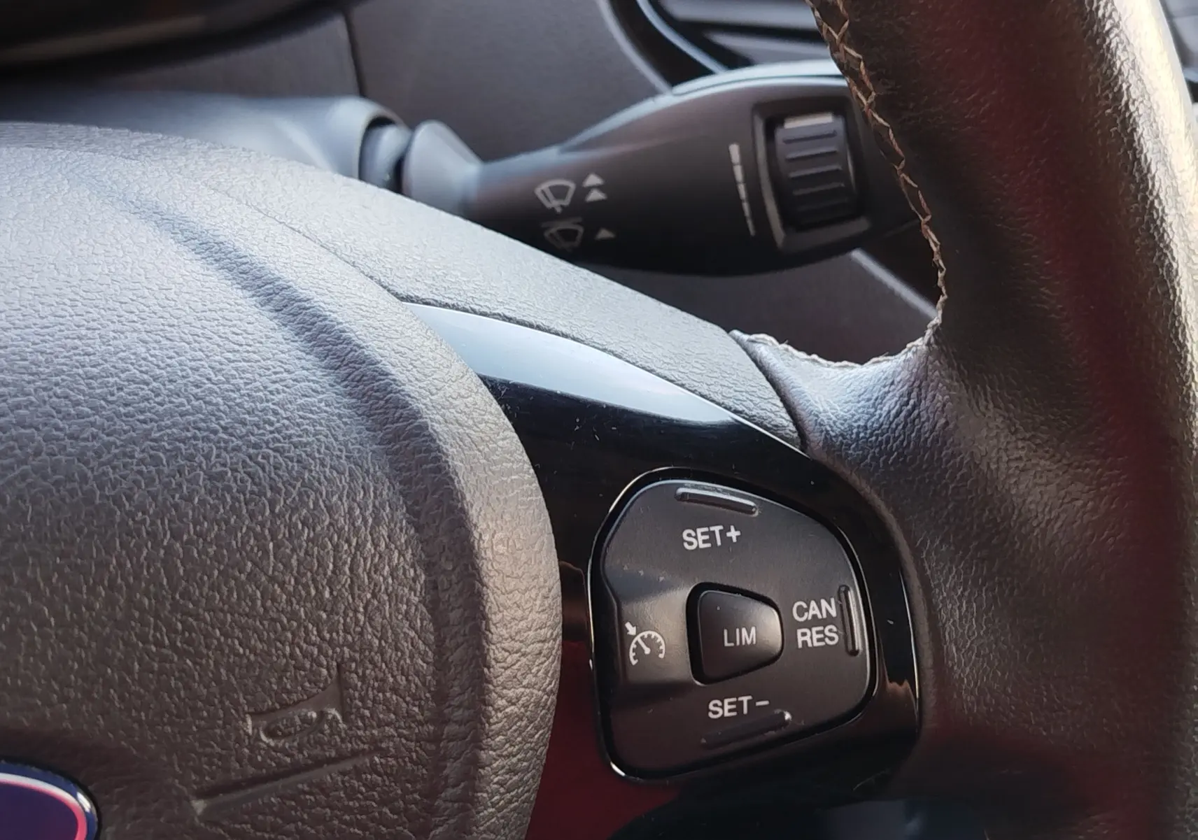 Gros plan sur les commandes de régulateur de vitesse à droite du volant en cuir noir du Ford KA+ 2020.