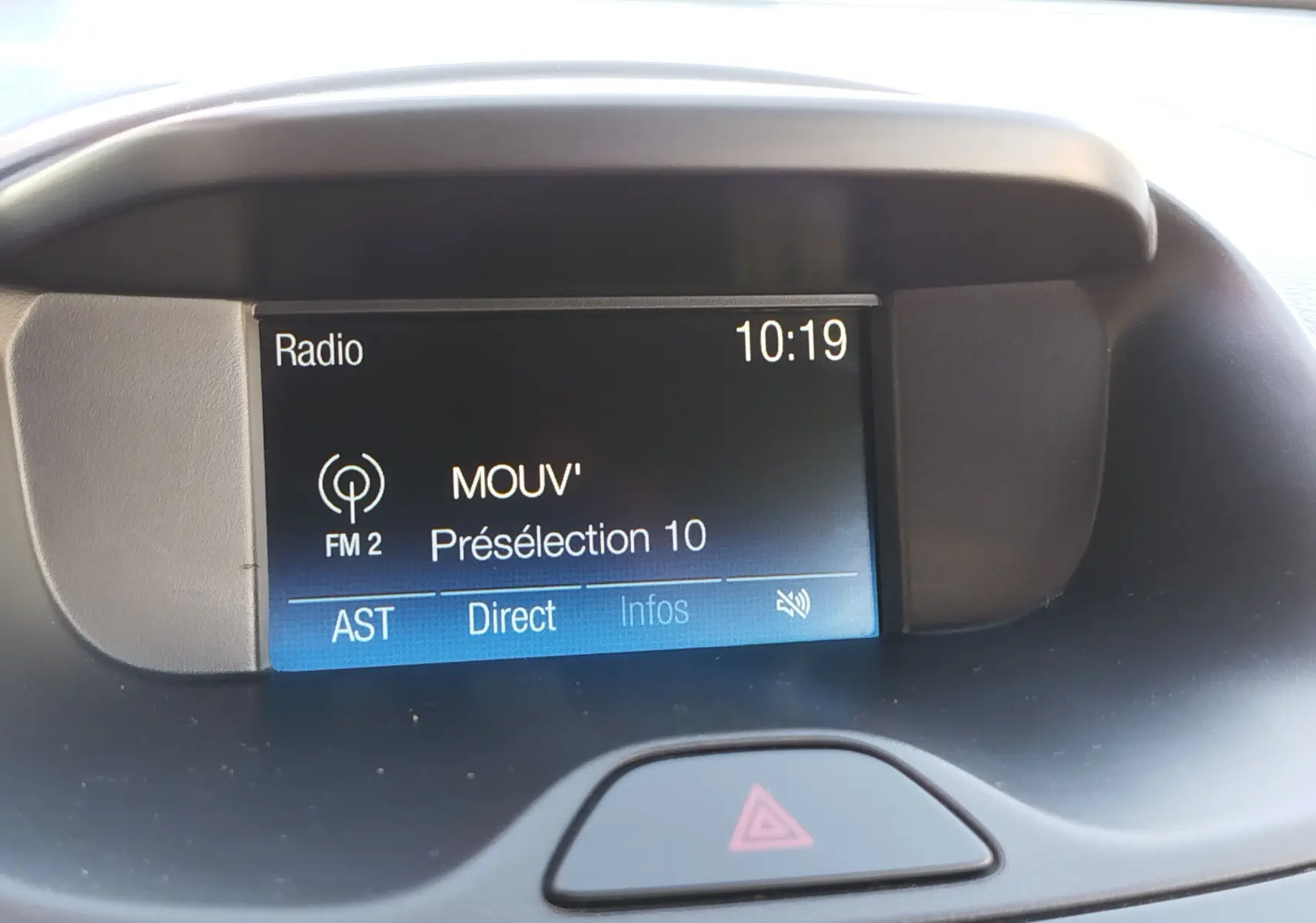 Écran central du tableau de bord du Ford KA+ 2020 affichant la radio FM2 sur la station MOUV', avec bouton de signal d'alerte visible.