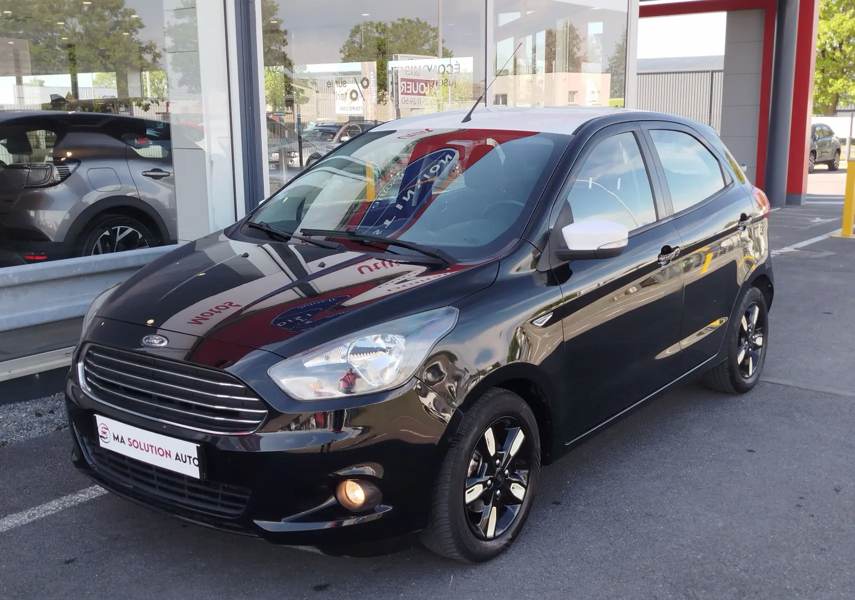 Ford KA+ 2020 noir Shadow avec toit blanc, vue 3/4 avant droit, jantes noires et rétroviseur blanc.