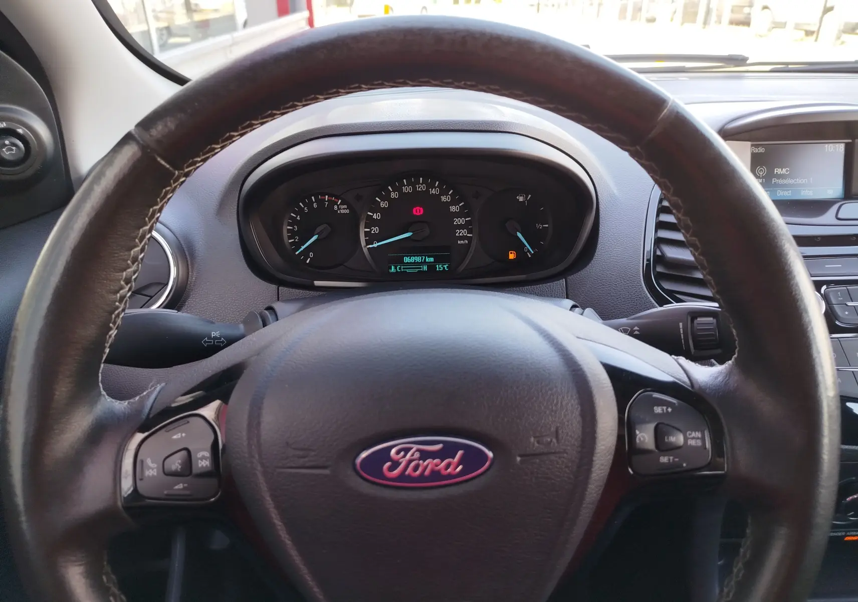 Intérieur du Ford KA+ 2020 vu côté conducteur, volant avec commandes intégrées et écran central affichant la radio.