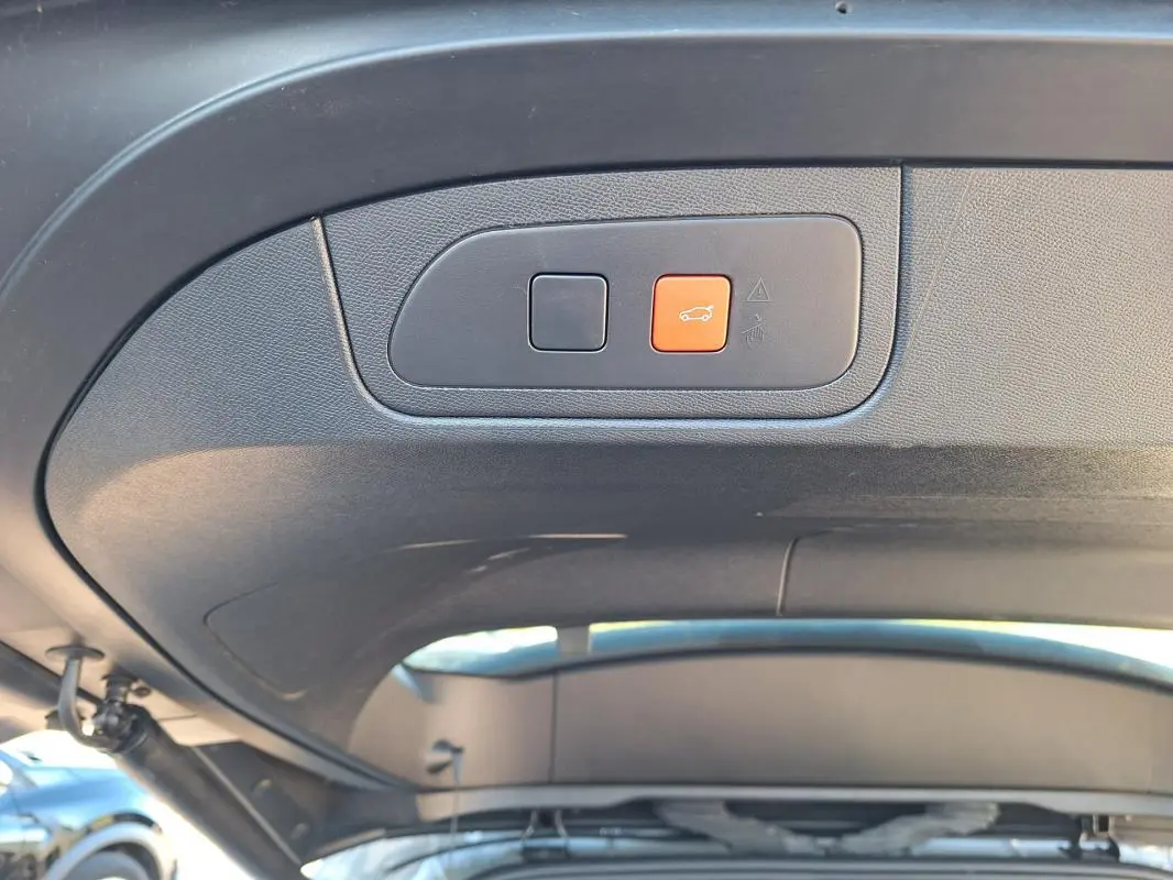 Boutons de commande de hayon électrique sur le panneau intérieur du coffre d’un DS7 gris 2025.