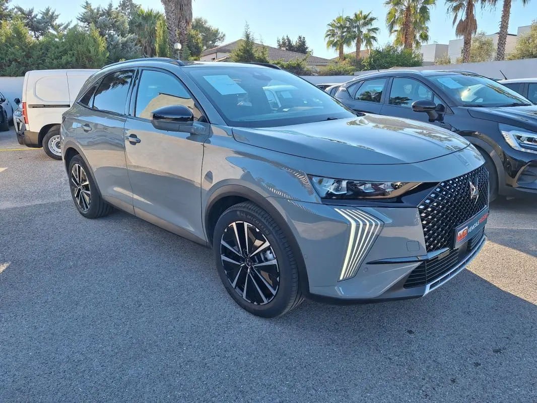 DS7 BlueHDi 130 EAT8 gris 3/4 avant droit, avec calandre distinctive et feux LED en forme de flèche.
