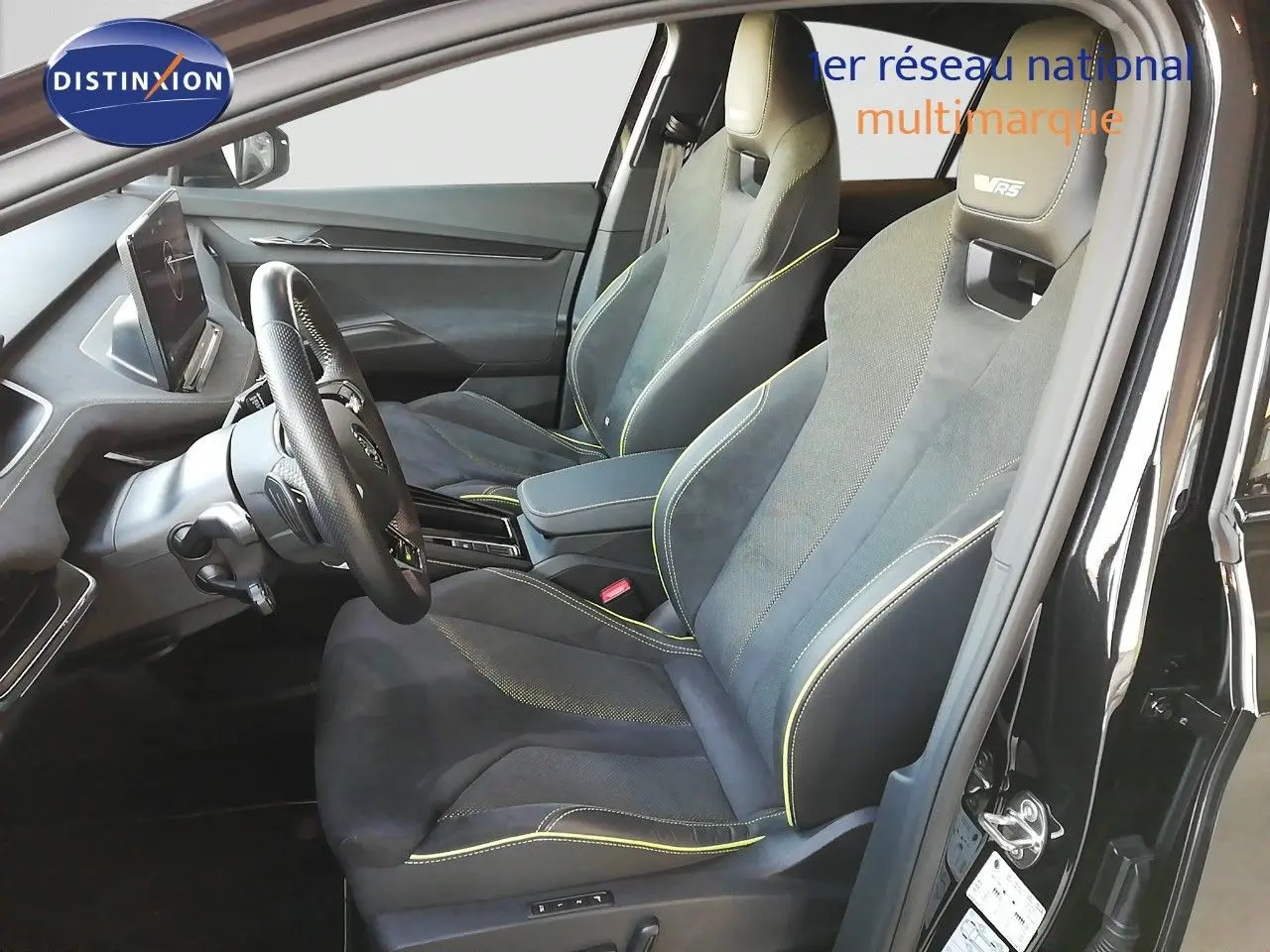 Vue intérieure côté conducteur du Skoda Enyaq Coupé noir métal 2022, sièges sport RS avec surpiqûres jaunes.