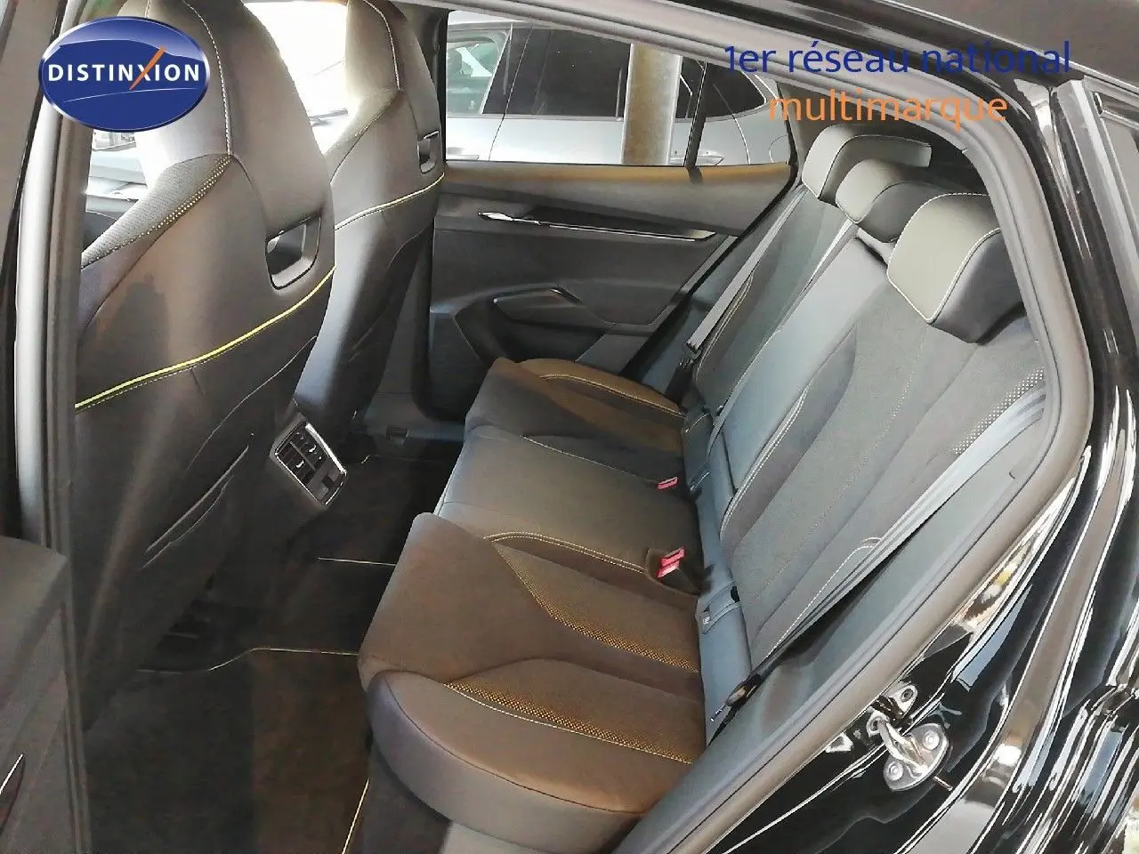 Vue latérale droite de l'intérieur arrière du Skoda Enyaq noir métal, montrant les sièges en cuir noir avec surpiqûres jaunes.