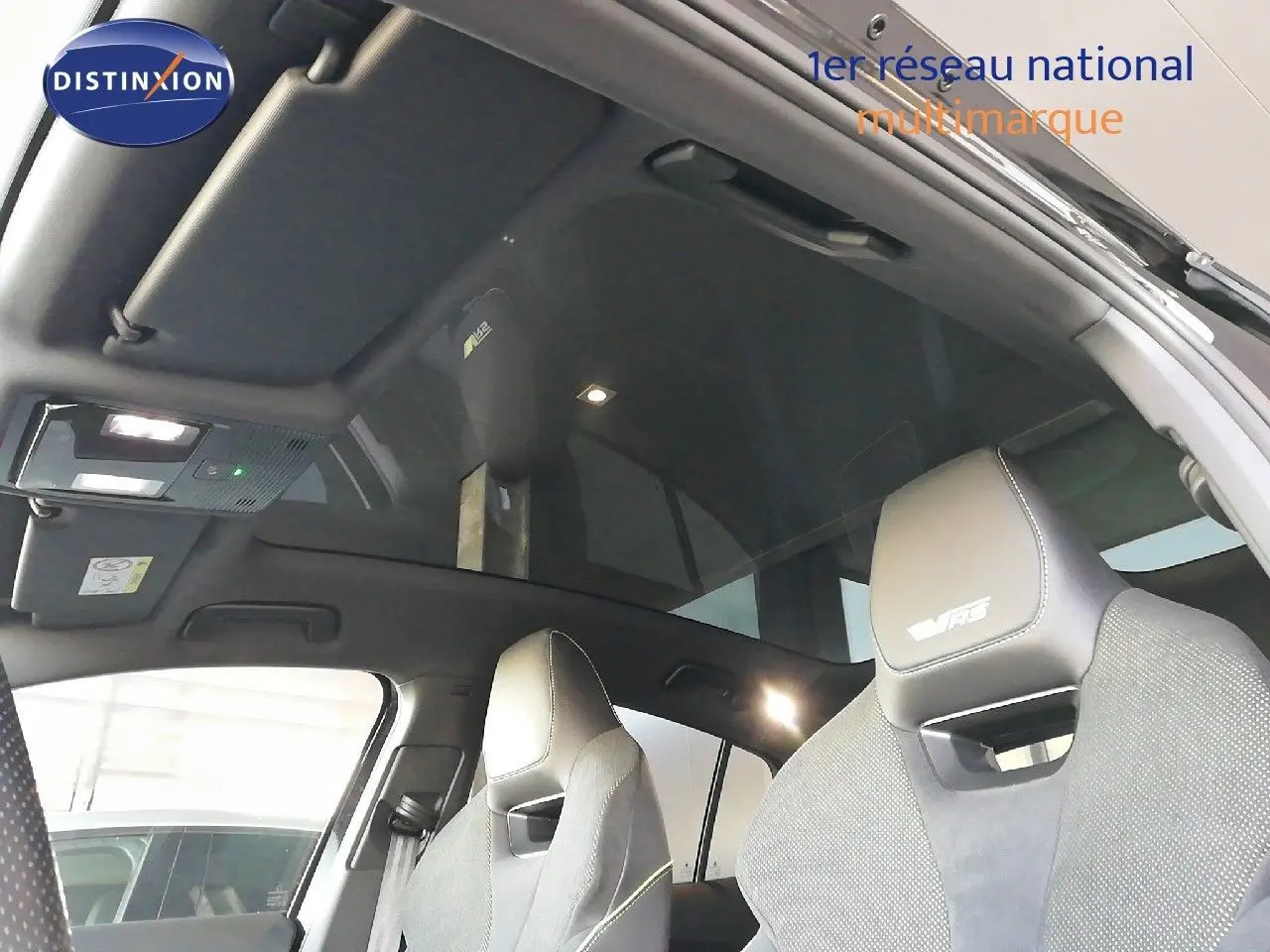 Intérieur du Skoda Enyaq RS noir métal 2022, vue sur sièges avant sport et toit panoramique en verre.