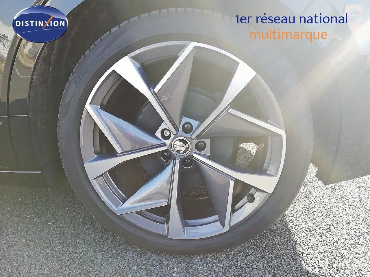 Gros plan sur la jante en alliage gris à cinq branches doubles du Skoda Enyaq noir métal, avec logo central visible.