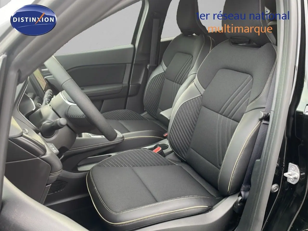 Vue intérieure côté conducteur du Renault Symbioz noir étoile métal 2025, mettant en valeur les sièges tissu noir avec surpiqûres claires.