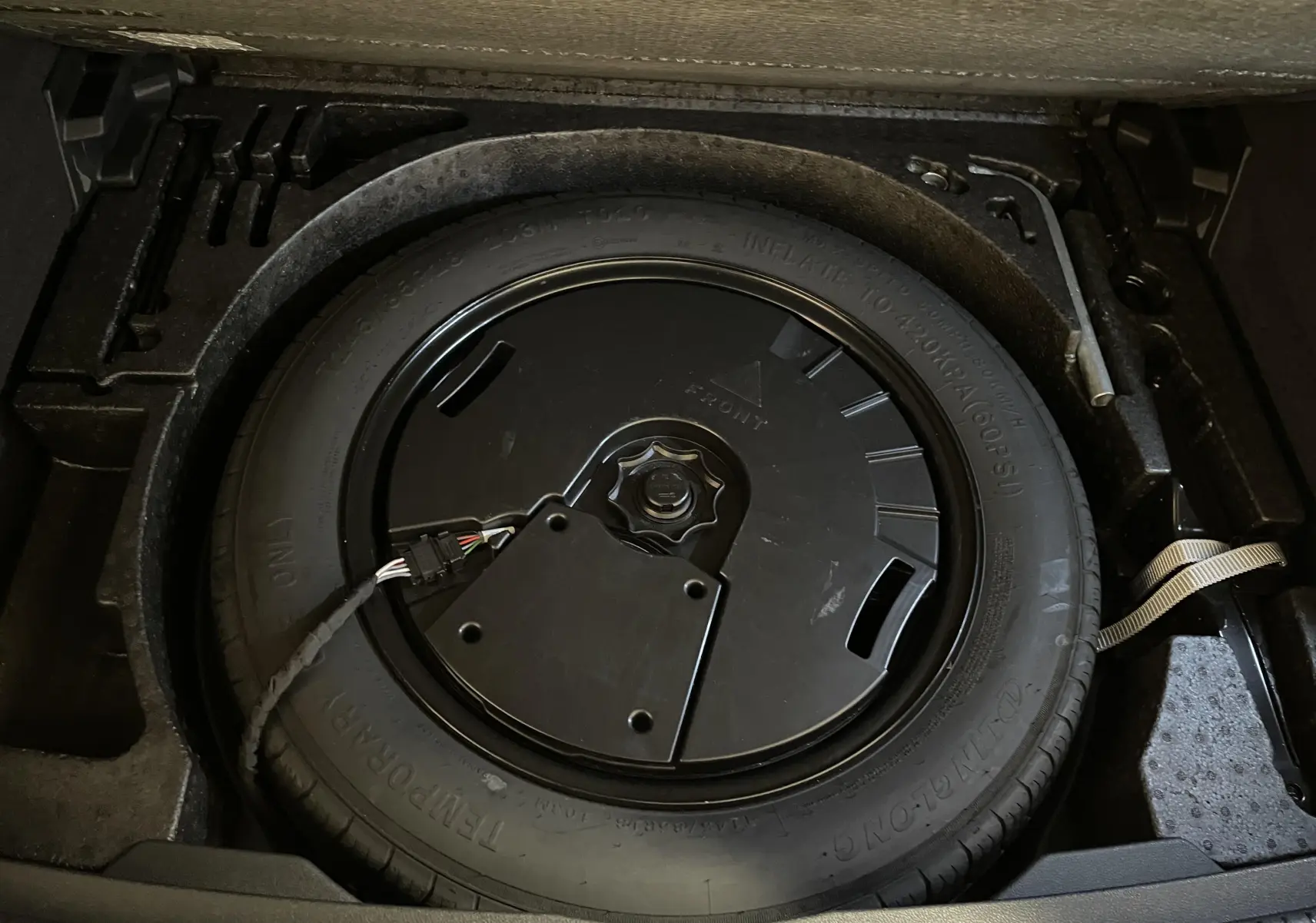 Roue de secours compacte dans le coffre du Volkswagen Tiguan 2022, détail du plancher de chargement variable.