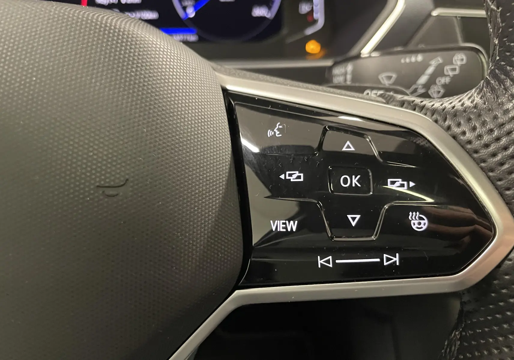 Gros plan sur les commandes noires du volant multifonction du Volkswagen Tiguan 2.0 TDI 2022.