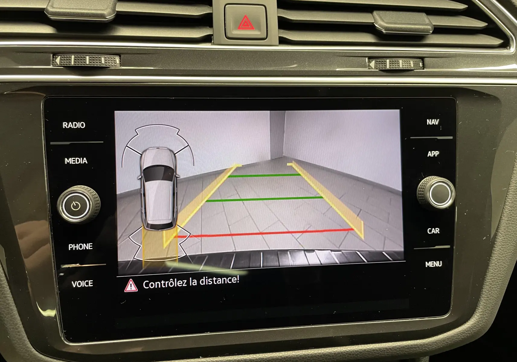 Écran de caméra de recul du Volkswagen Tiguan 2022 montrant les lignes de guidage dans un espace de stationnement intérieur.