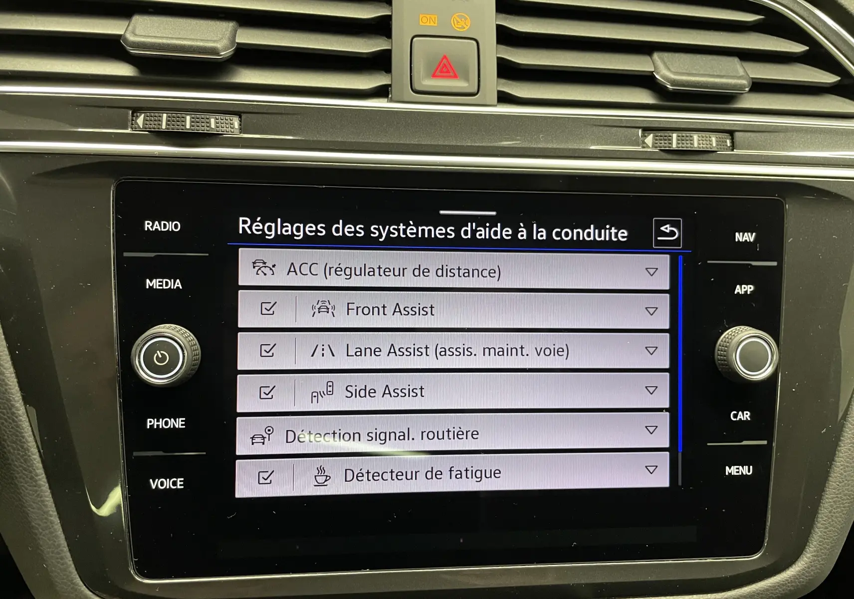 Écran tactile intérieur du Volkswagen Tiguan 2022 affichant les réglages des aides à la conduite.