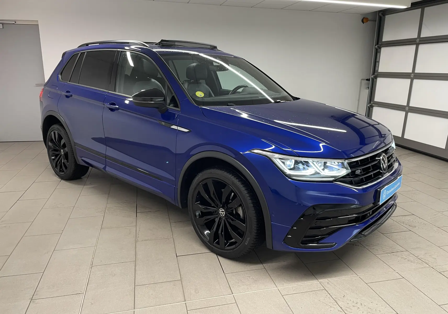 Volkswagen Tiguan Bleu Lapiz en 3/4 avant droit, avec calandre noire et jantes noires 20'' Suzuka.