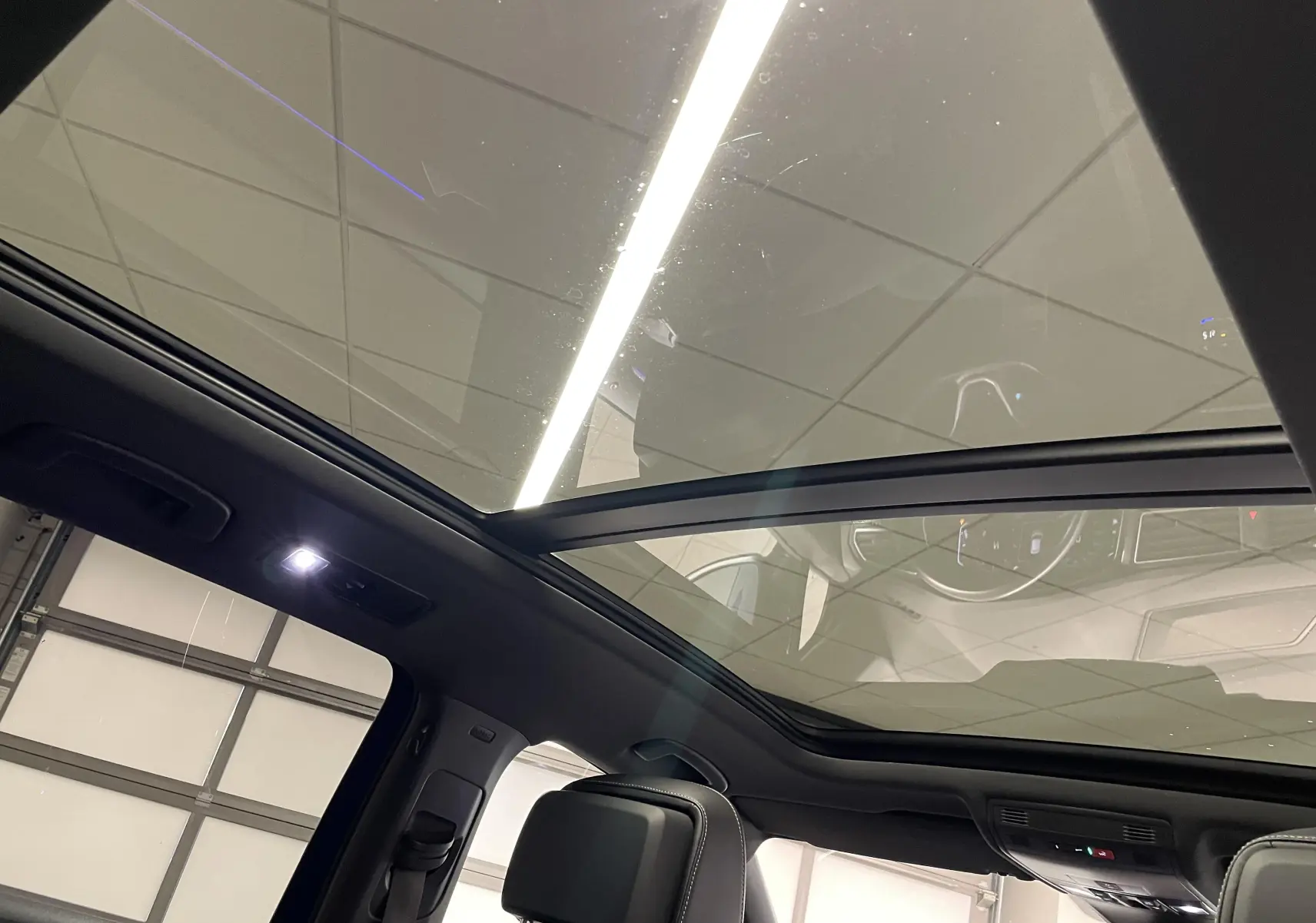 Vue intérieure du toit ouvrant panoramique du Volkswagen Tiguan Bleu Lapiz, mettant en valeur l'habitacle lumineux et moderne.