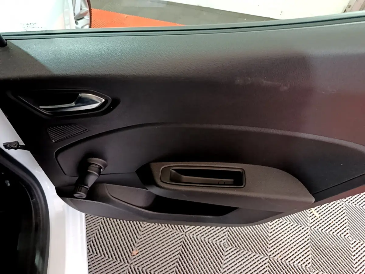 Vue intérieure côté gauche de la porte arrière blanche de la Renault Clio Business TCe 90 avec poignée et manivelle de vitre.