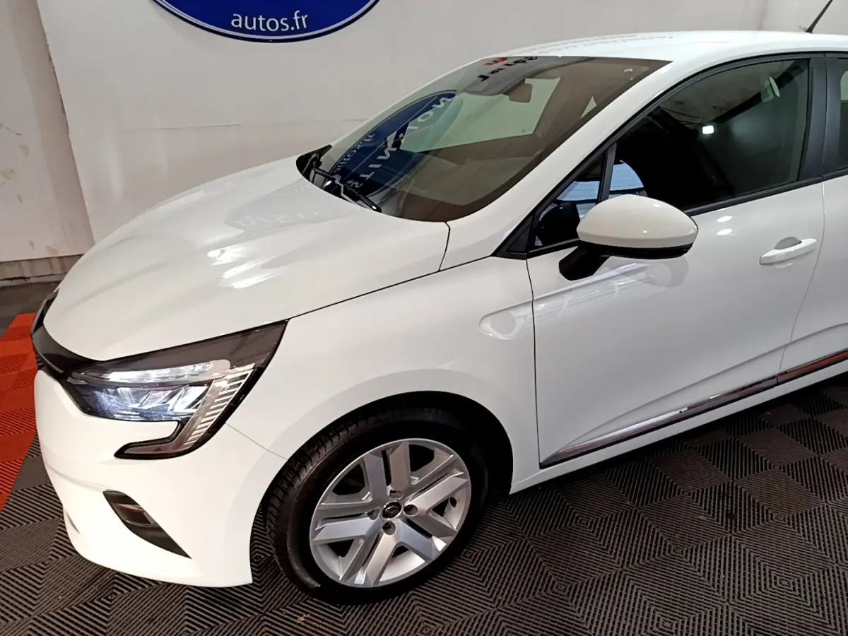 Vue 3/4 avant droit d'une Renault Clio Business TCe 90 blanche avec phares LED et jantes alliage argentées.