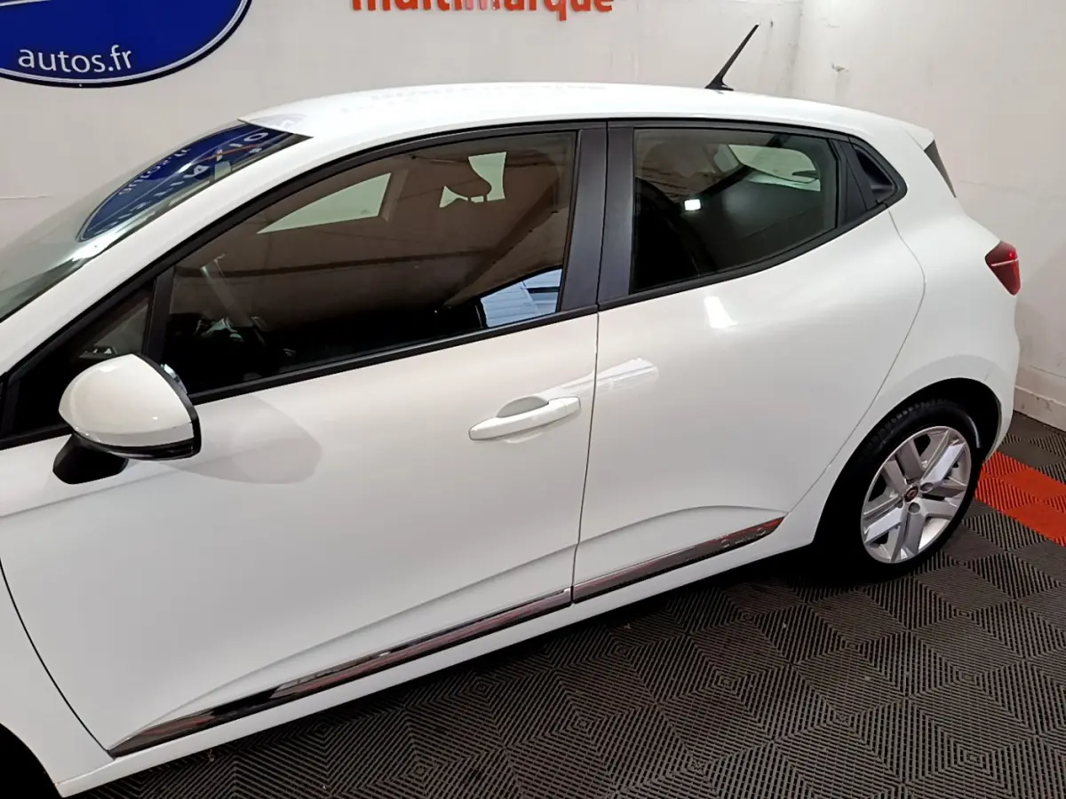 Profil droit d'une Renault Clio Business TCe 90 blanche, avec jantes alliage et rétroviseur blanc contrasté noir.