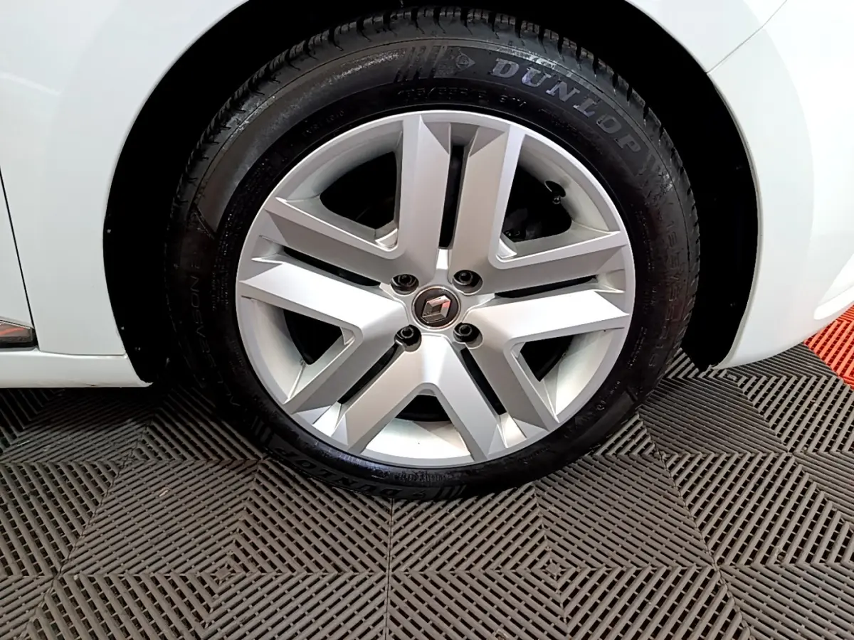 Gros plan sur la roue avant droite blanche d'une Renault Clio Business TCe 90 2021 avec jante alliage et logo Renault.