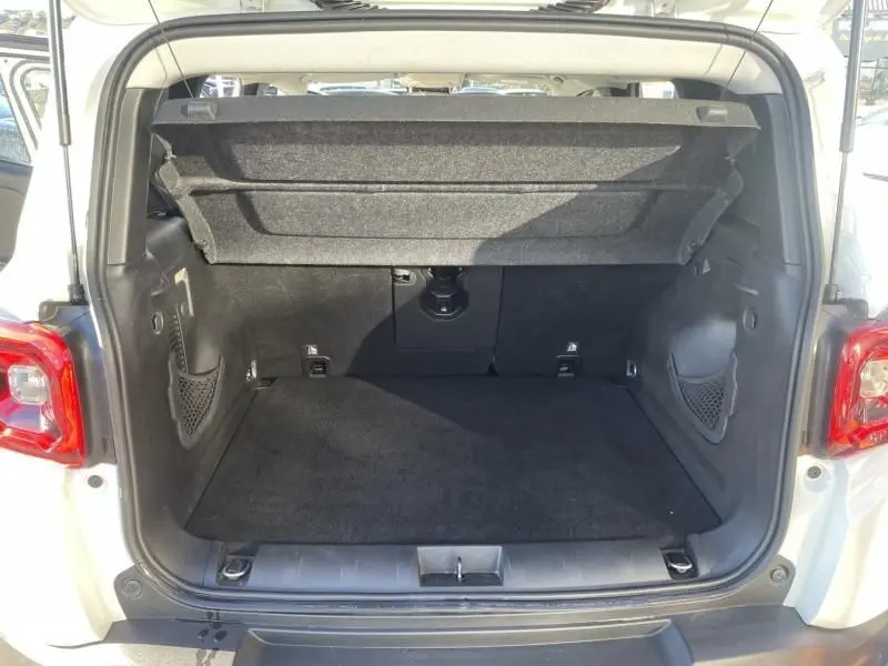 Coffre ouvert vu de l'arrière d'un Jeep Renegade blanc 2019, montrant l'espace de chargement et les filets latéraux.