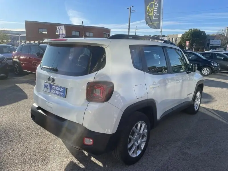 Jeep Renegade blanc en 3/4 arrière droit, avec feux arrière caractéristiques et jantes alliage visibles.