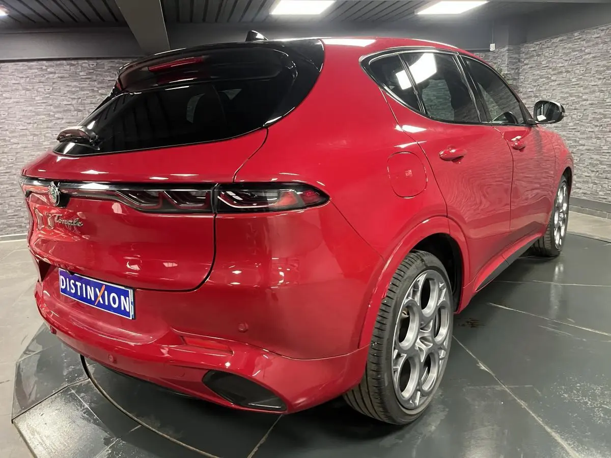 Vue 3/4 arrière droite de l'Alfa Romeo Tonale rouge avec toit noir et jantes alliage 20 pouces Competizione.