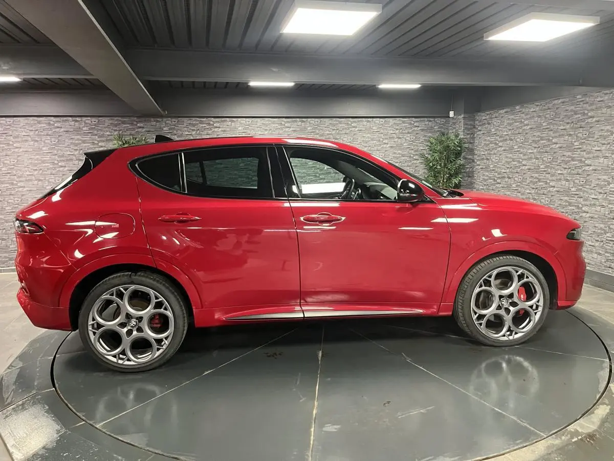 Profil droit de l'Alfa Romeo Tonale rouge 2024 avec jantes 20 pouces et étriers de frein rouges visibles.