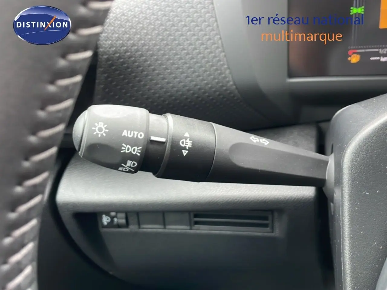 Gros plan sur la commande des phares à gauche du volant d’une Citroën C4 blanc métal, version PureTech 130ch.