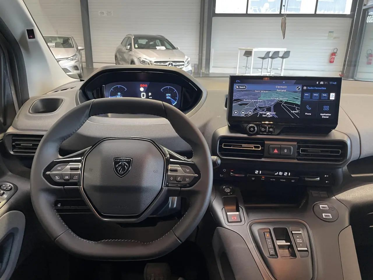 Vue intérieure frontale du tableau de bord du Peugeot Rifter gris Artense avec volant cuir multifonction et écran tactile.