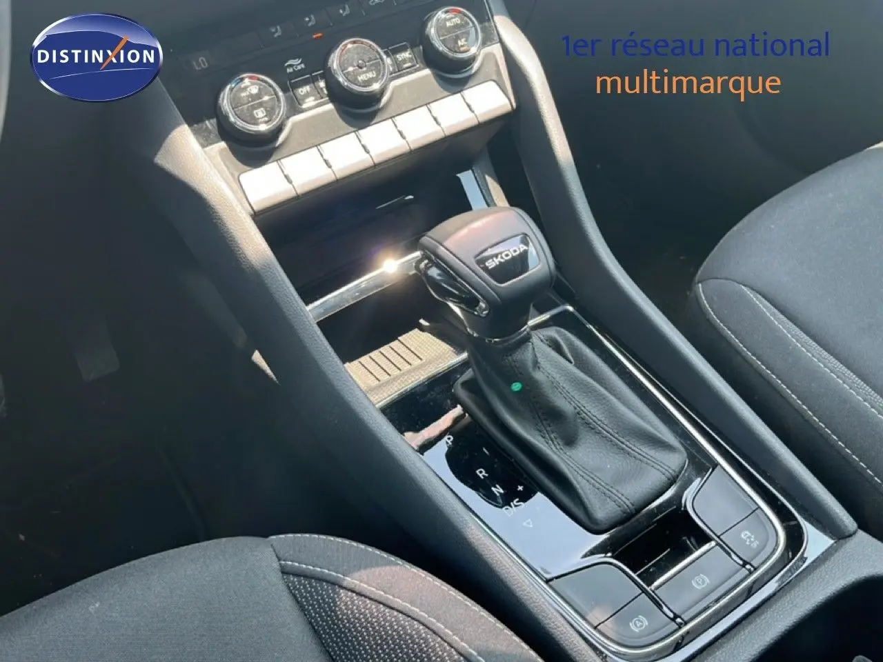 Gros plan sur la console centrale d’un Skoda Karoq 2025, levier de vitesse DSG noir avec logo Skoda visible.