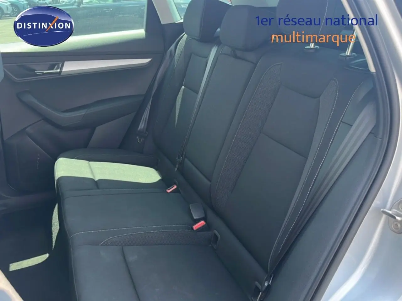 Vue intérieure côté gauche montrant la banquette arrière noire du Skoda Karoq Reflex Silver 2025 avec porte ouverte.