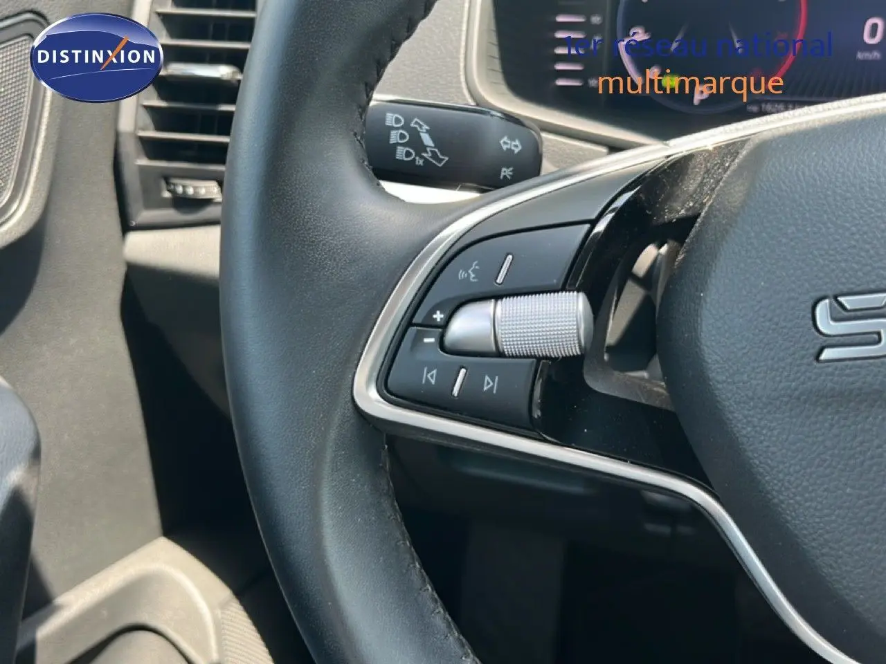 Gros plan sur le volant noir avec commandes intégrées du Skoda Karoq 2025 en Reflex Silver Metal.