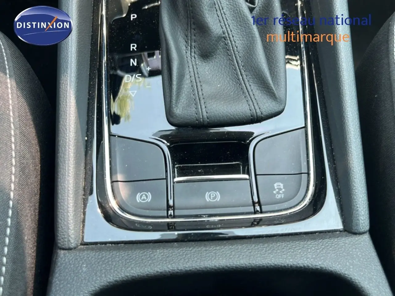 Gros plan sur la console centrale noire brillante avec levier de vitesse cuir et boutons de contrôle du SKODA KAROQ 2025.