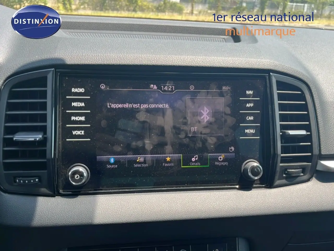 Écran tactile central du tableau de bord d'une Skoda Karoq 2025, avec interface multimédia et commandes autour.