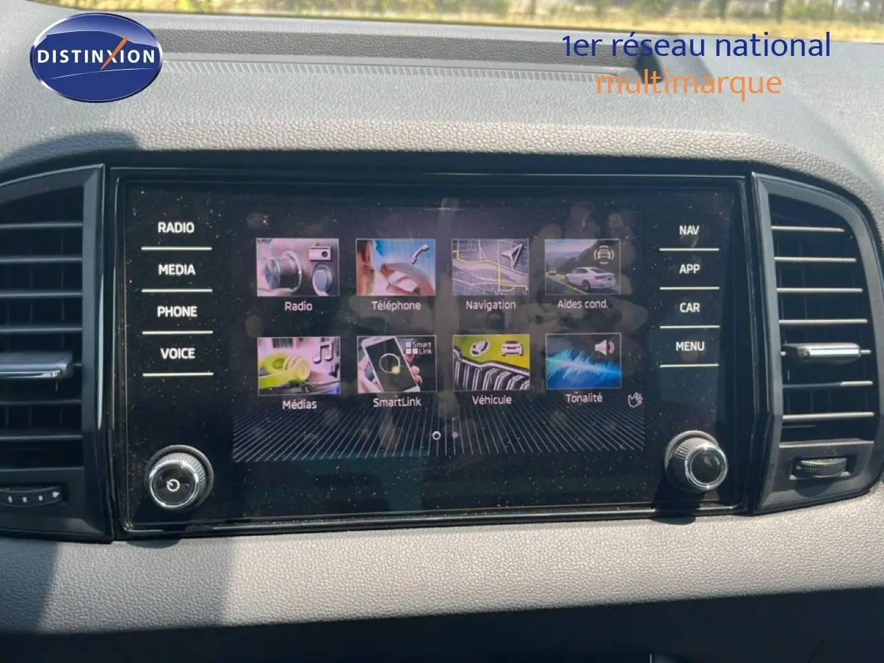 Écran tactile central du Skoda Karoq 2025 affichant les menus radio, navigation et téléphone, entouré de commandes.