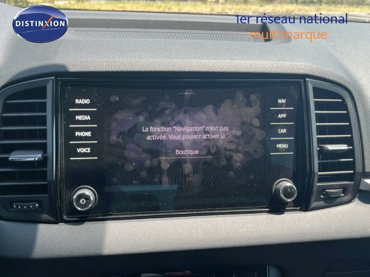 Écran tactile central du tableau de bord du Skoda Karoq 2025, avec commandes radio et navigation visibles.