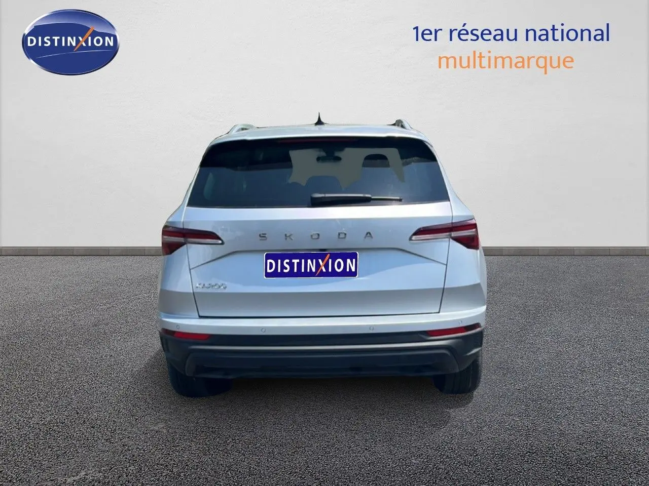 Vue arrière d'un Skoda Karoq 2025 en argent Reflex Silver Metal, avec feux arrière LED et logo distinctif.